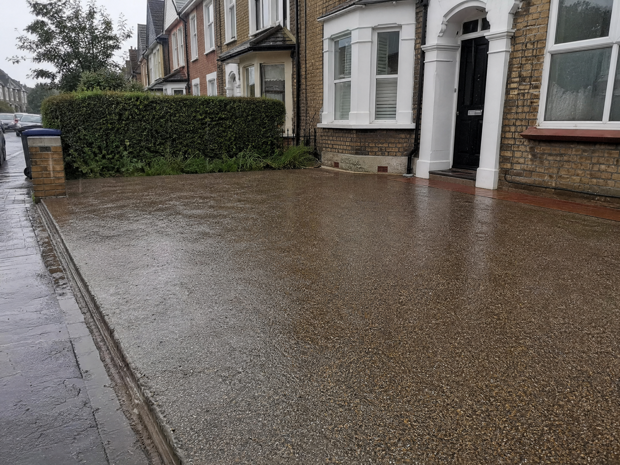 Rain soaking into a permeable resin bound driveway instead of running to the road