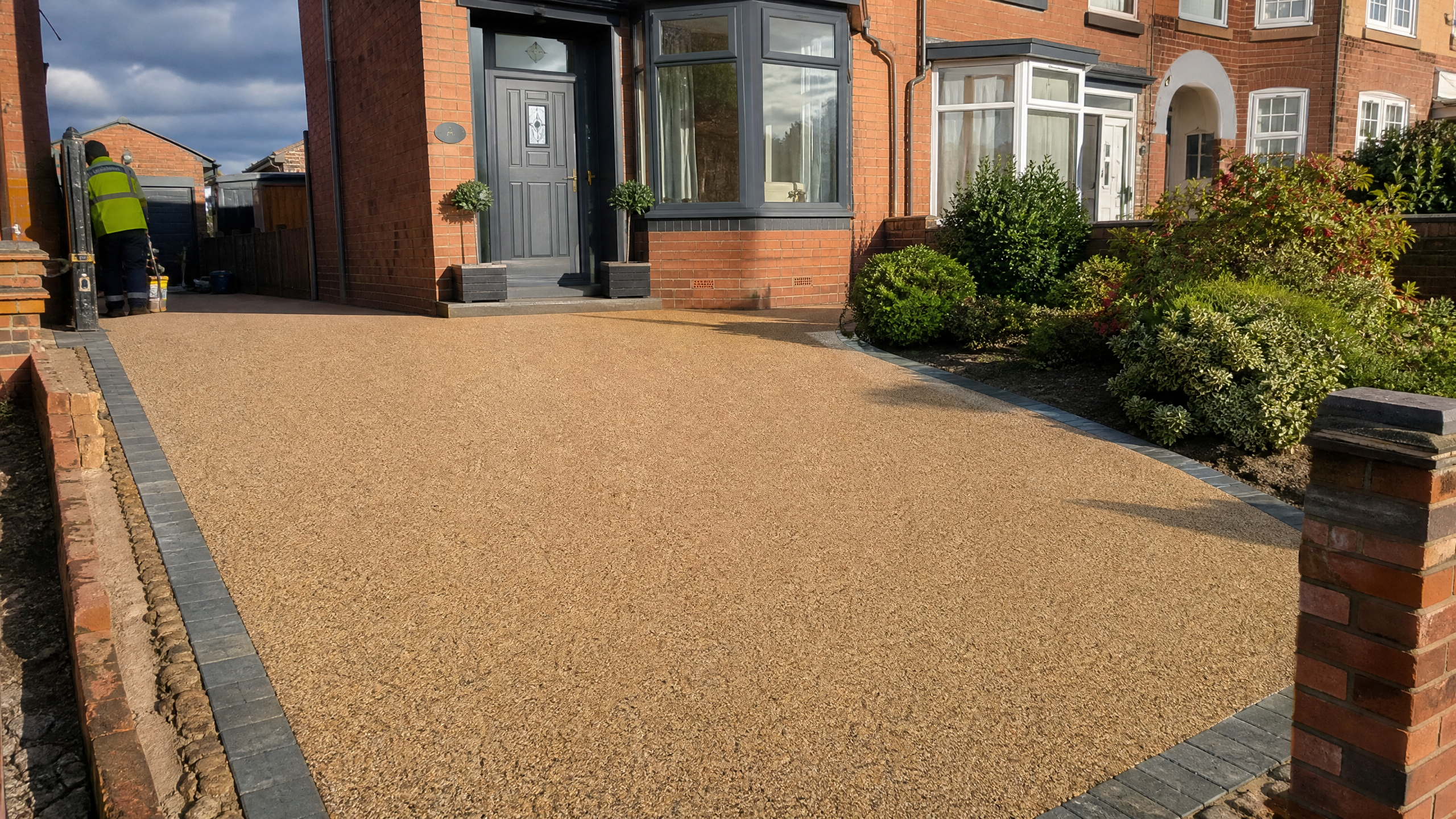 Newly laid resin bound driveway in a warm golden stone blend in front of a red-brick house in Kettering